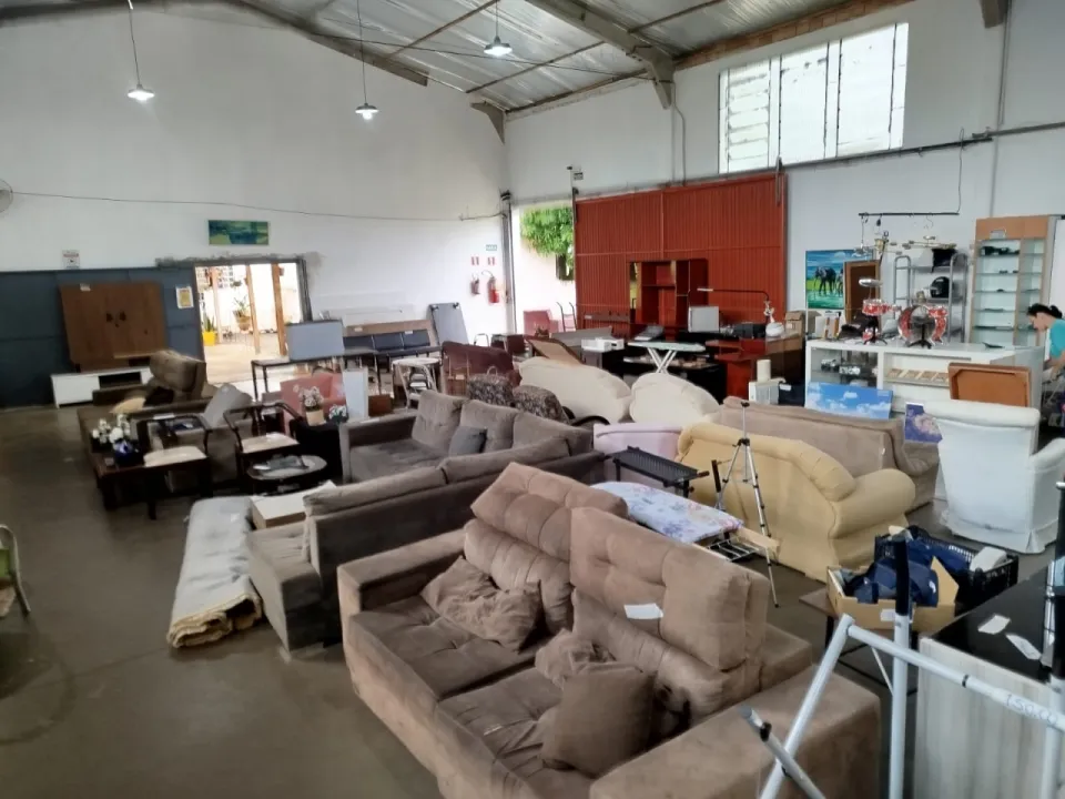 Galpão do bazar com sofás, poltronas, mesas e armários expostos à venda